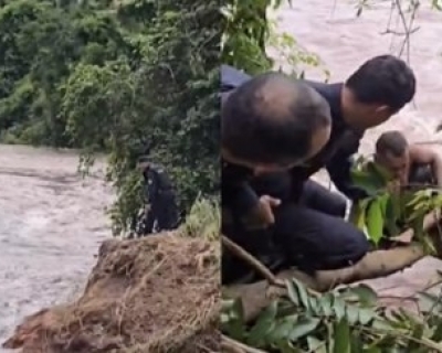 Menino � resgatado por PMs ap�s ficar preso em rio durante tromba d��gua