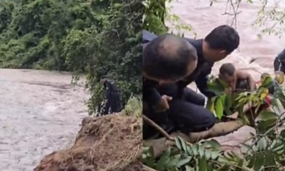 Menino é resgatado por PMs após ficar preso em rio durante tromba d’água
